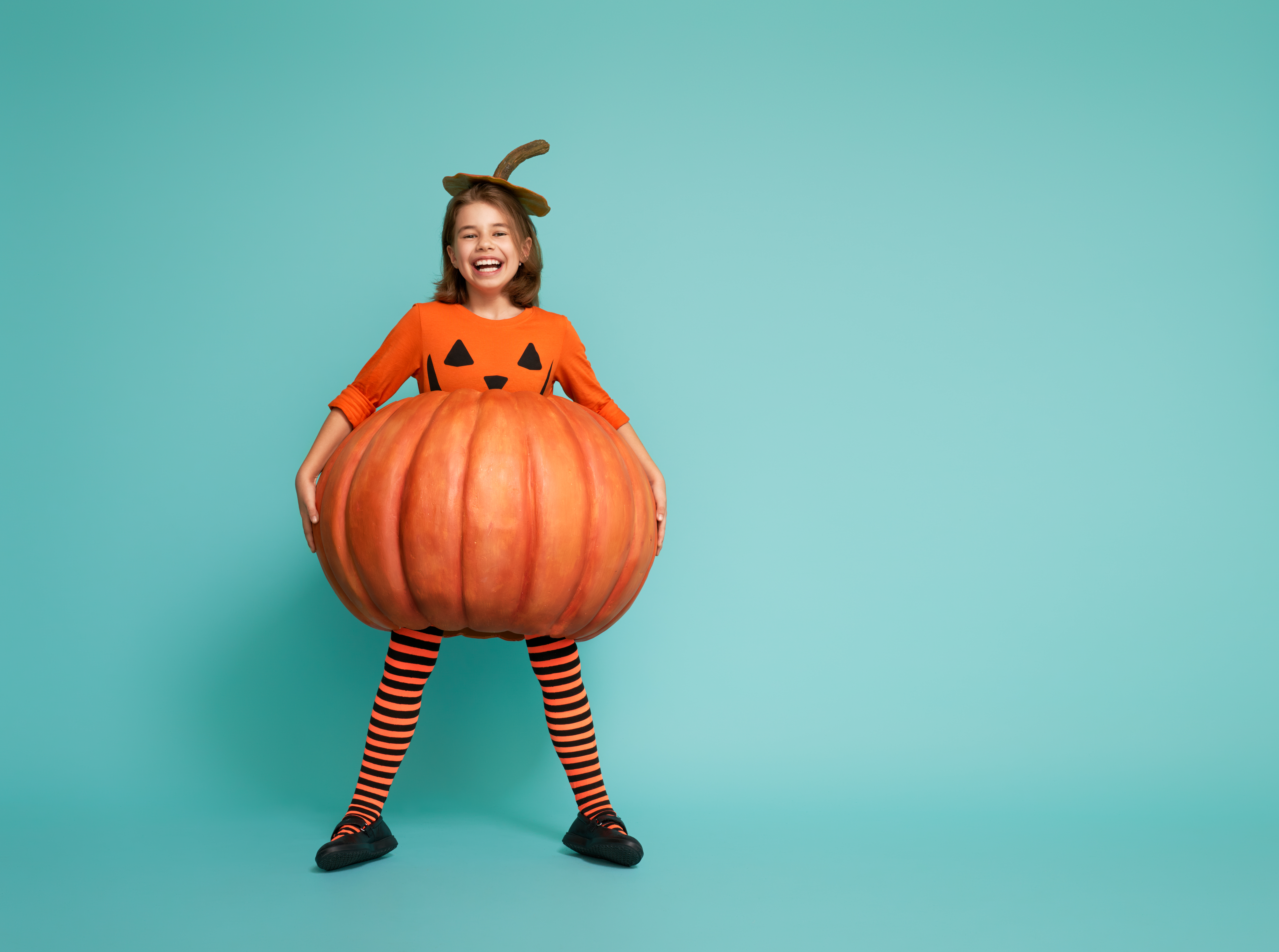 Happy,Halloween!,Cute,Little,Girl,In,Pumpkin,Costume,On,Turquoise